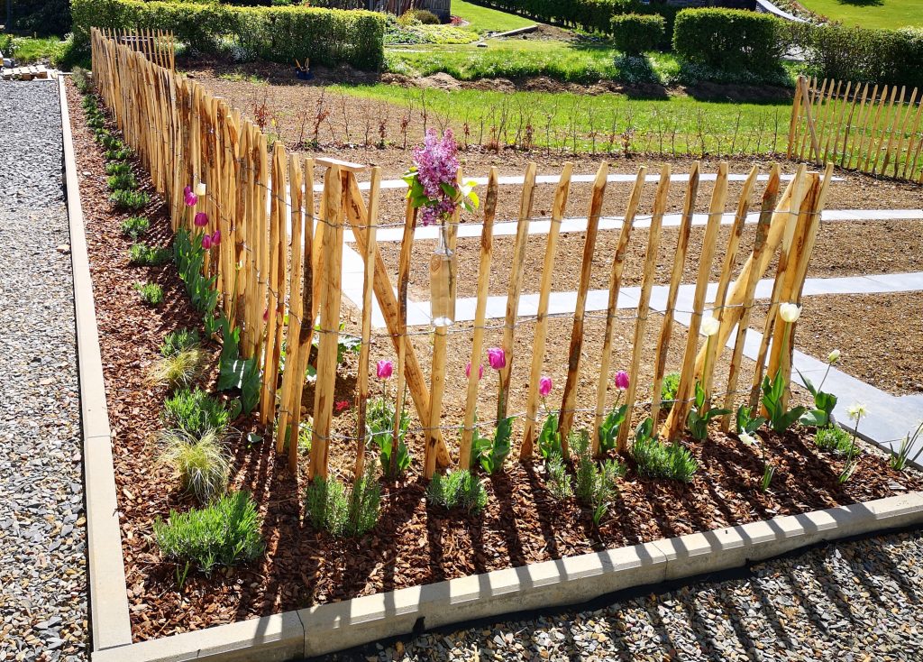 Sfeervolle tuin met houten schutting, terras en tuinverlichting voor extra gezelligheid en comfort